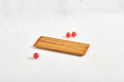 One short teak cheeseboard with beveled edges, displayed on a white background, showcasing its smooth surface and natural wood grain.