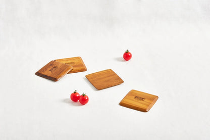 Set of four square teak coasters with beveled edges, displayed on a white background, highlighting their natural wood grain and smooth finish.