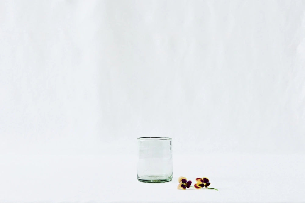 Clear short glass tumbler, made from 100% recycled glass, shown from the side on a white background.