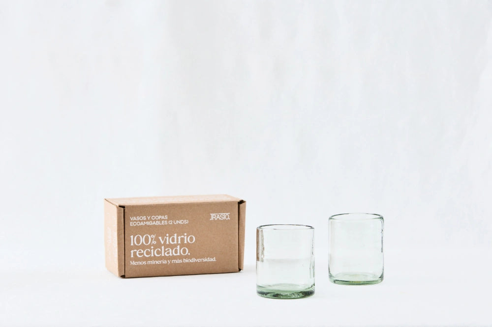 Two clear short glass tumblers, made from 100% recycled glass, standing side by side on a white background.