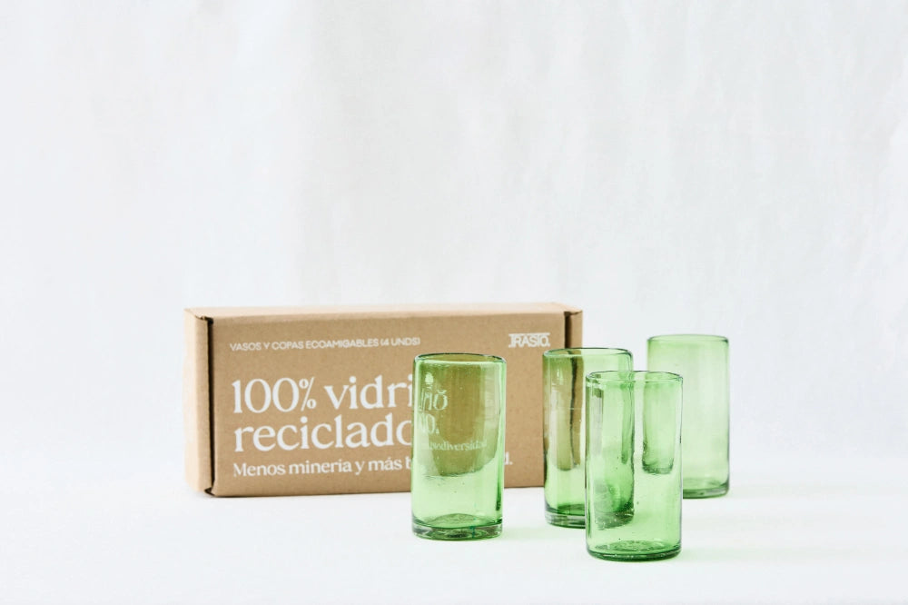 Four green lightly tinted tall highball glasses, made from 100% recycled glass, shown side by side with packaging on a white background."