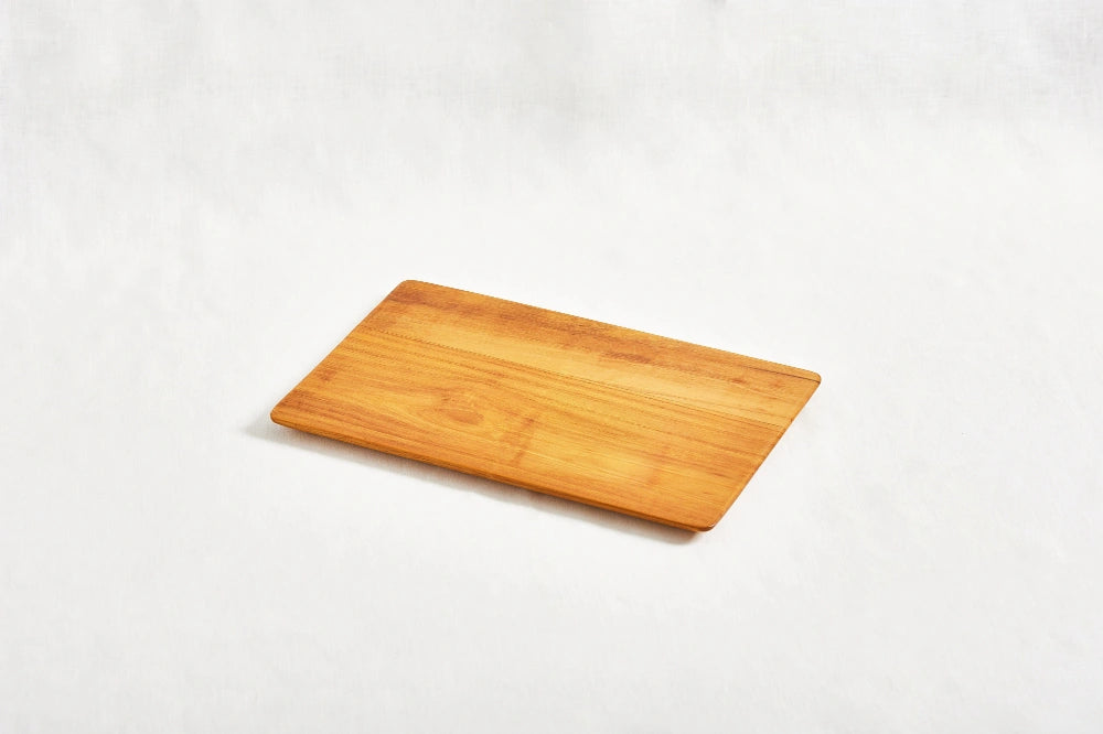 One small super lightweight cutting board made from 100% certified teak wood, featuring a beveled edge, displayed on a white background.