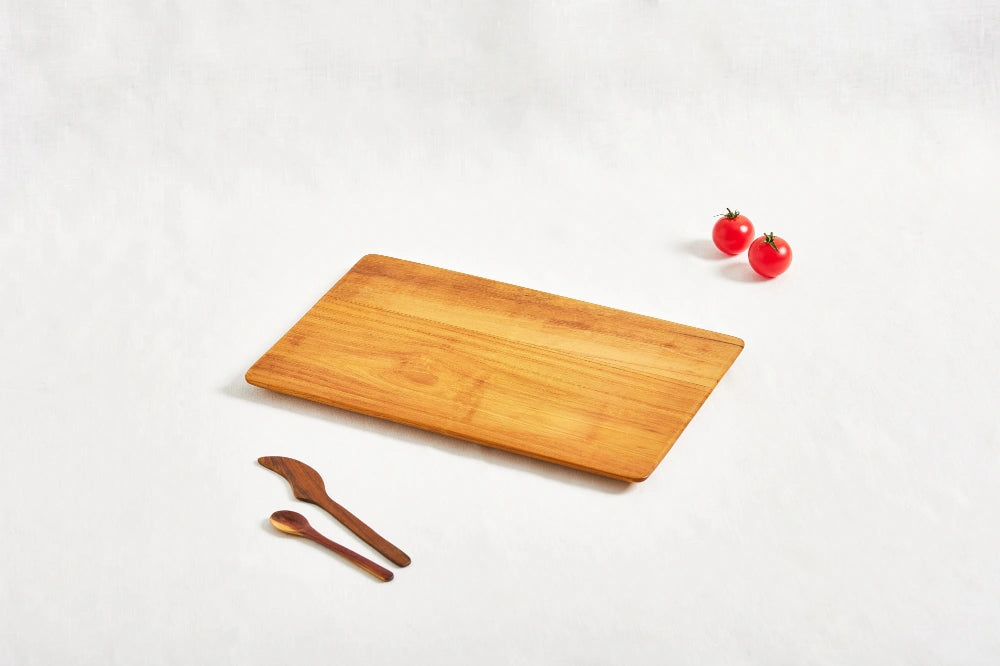 One small super lightweight cutting board made from 100% certified teak wood, featuring a beveled edge, displayed on a white background.