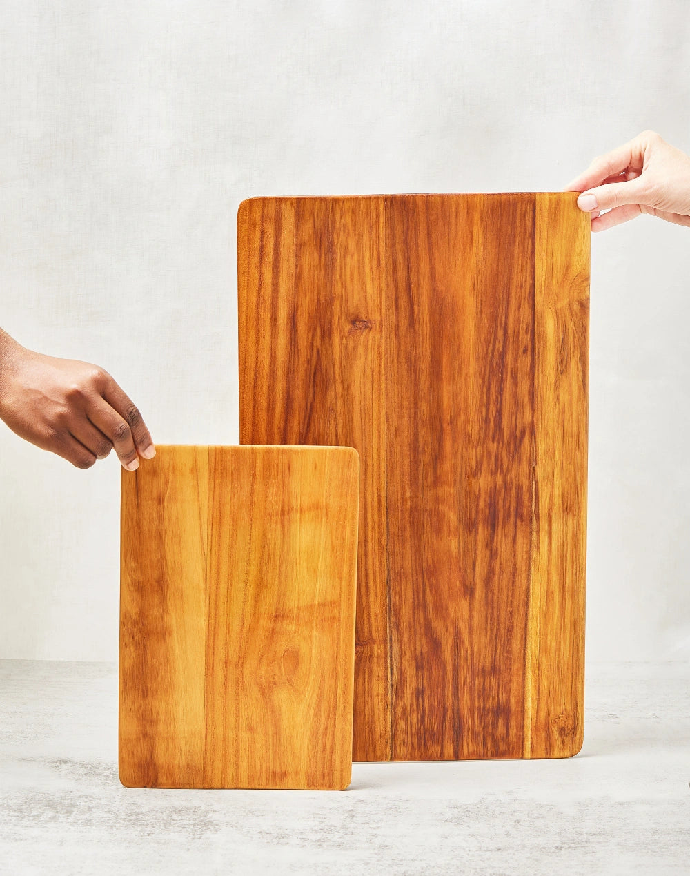 Large and short super lightweight cutting boards made from 100% teak wood, featuring beveled edges, shown standing upright to display their smooth main surfaces.