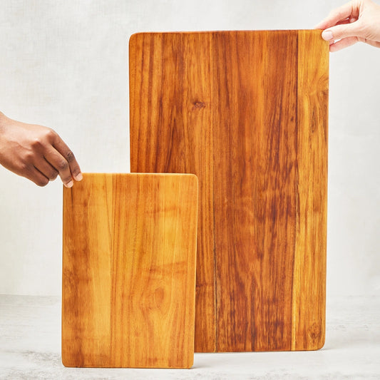 Large and short super lightweight cutting boards made from 100% teak wood, featuring beveled edges, shown standing upright to display their smooth main surfaces.