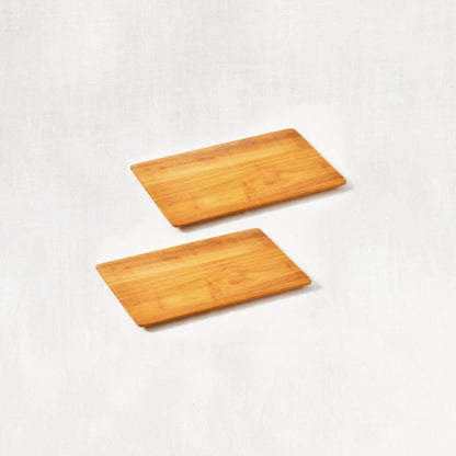 Two small super lightweight cutting boards made from 100% certified teak wood, featuring beveled edges, displayed side by side on a white background.