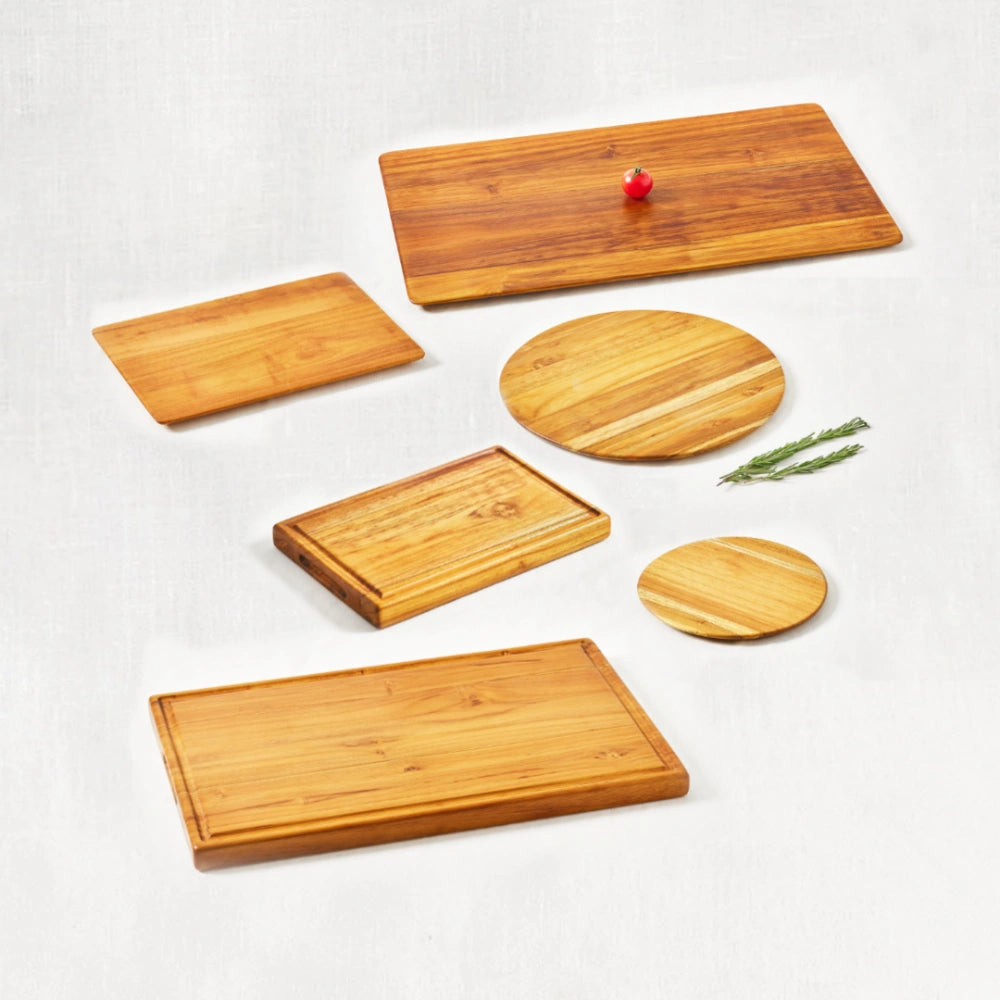 Barbecue kit with cutting boards and trays made from 100% certified teak wood, showcasing durable construction and rich wood grain, arranged together on a white background.