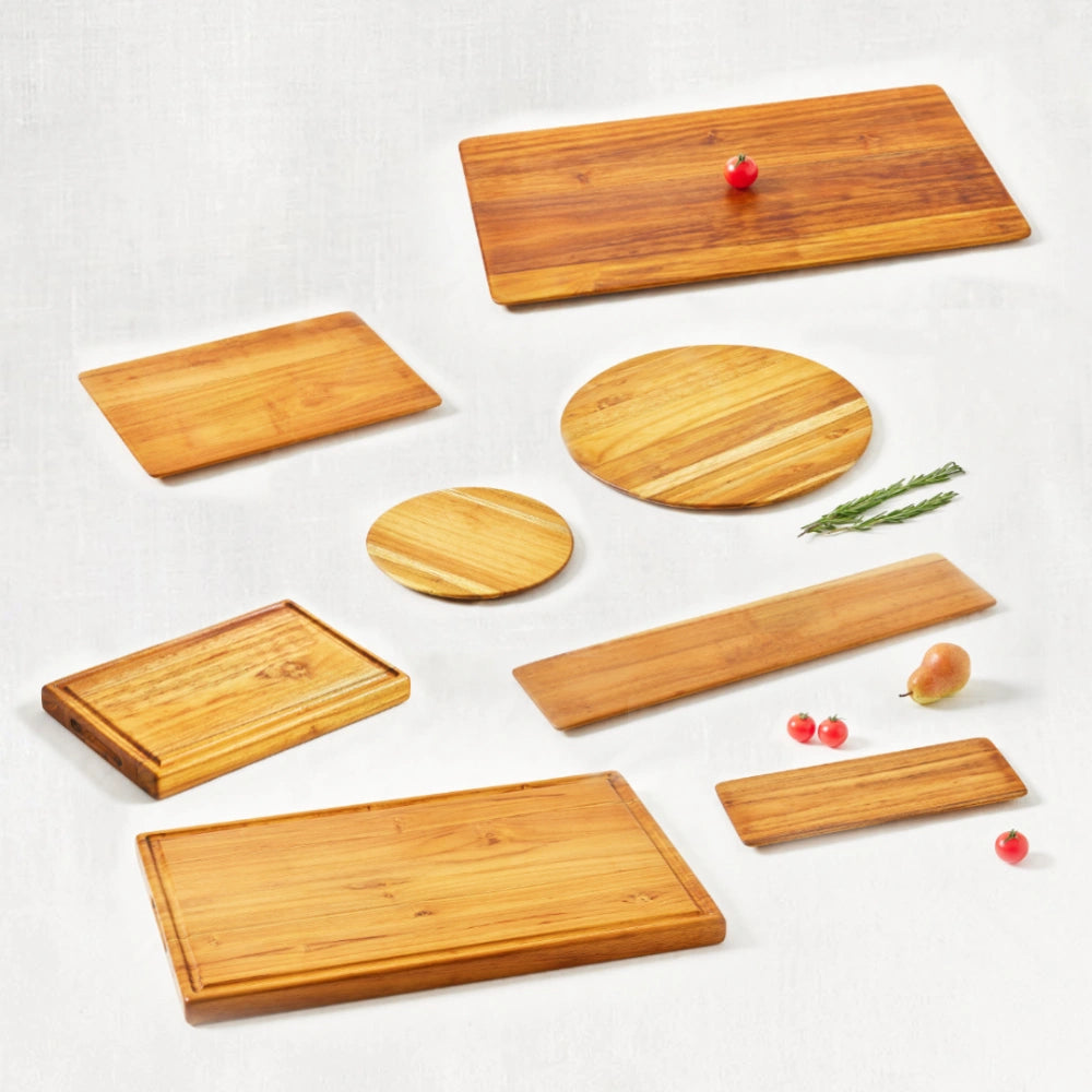 Family kit of cutting boards and trays made from 100% certified teak wood, featuring a smooth finish and natural wood grain, displayed together on a white background.